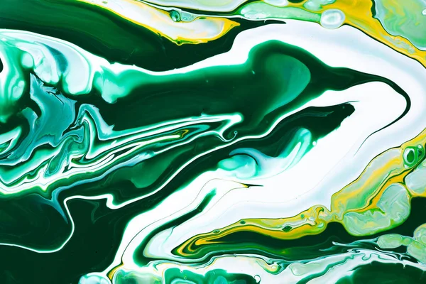 Fluid art texture. Abstract background with swirling paint effect. Liquid acrylic picture with flows and splashes. Mixed paints for baner or wallpaper. Yellow, emerald and white overflowing colors.