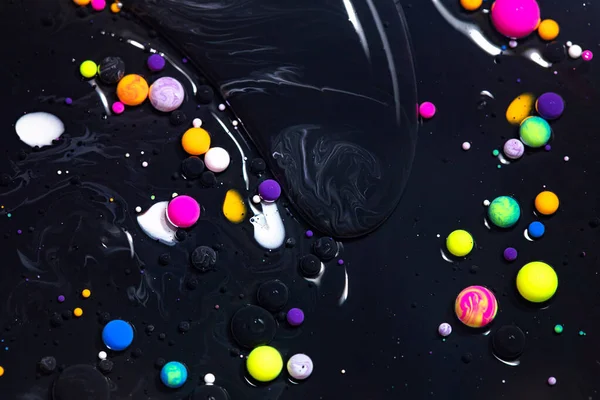 Fluid art texture. Background with abstract mixing paint effect. Liquid acrylic picture with flowing bubbles. Mixed paints for posters or wallpapers. Black and colorful overflowing colors.