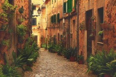 Güneşli bir yaz günü Alp gölünde, ağaçlar, çimenler ve çalılar dağların yamaçlarında yetişir, gökyüzü sudaki dağlar ve ağaçları yansıtır, bulutsuz berrak mavi gökyüzü, uzak yamaçlarda evler vardır.