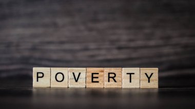 hafif ahşap plakalar koyu ahşap arka plan üzerinde oluşan kelime yoksulluk