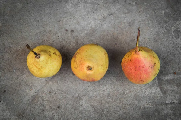 Gri beton zemin üzerine olgun sarı armut