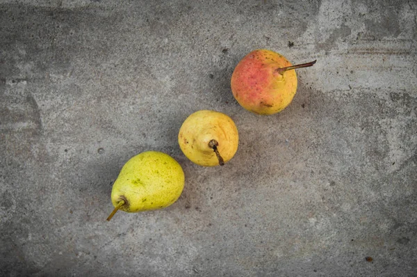 Gri beton zemin üzerine olgun sarı armut