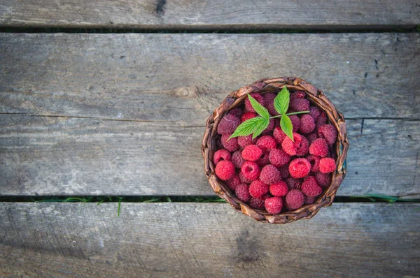 ahşap arka plan üzerinde bir sepet içinde olgunlaşmış ahududu