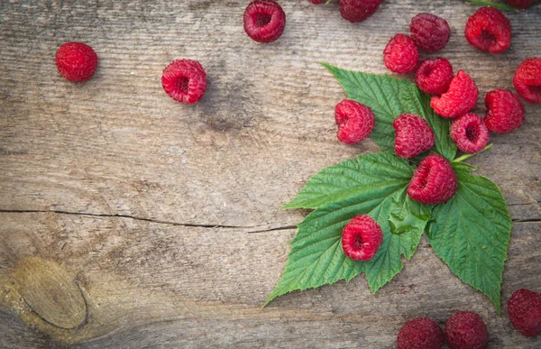 ahşap backg üzerinde bir saçılma Ahududu ve Ahududu yaprakları