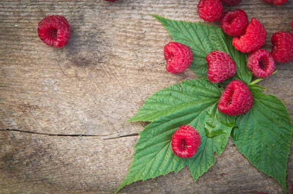 ahşap backg üzerinde bir saçılma Ahududu ve Ahududu yaprakları