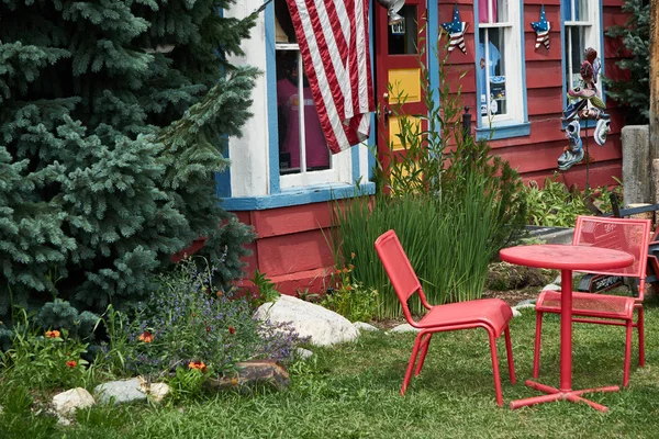 Açık bir masa ve sandalyeler üzerinde uçan Amerikan bayrağı ile renkli yard
