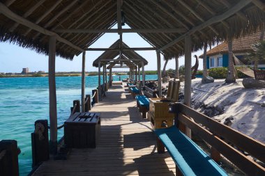  Aruba'daki Rönesans Adası'ndaki tekne iskelesinde sazdan çatılar öğleden sonra güneşinden koruma sağlar