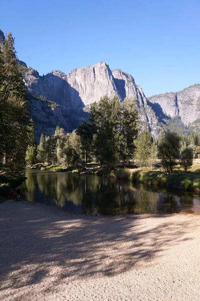Sandbar in the Merced River leads the tourist into the cool water flow