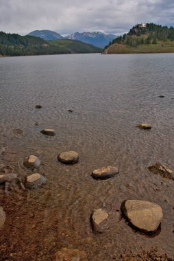 Bulutlu gökyüzü ile bir dağ gölünü seyretmek