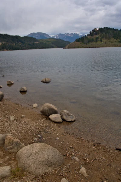 山地湖泊前景中的巨石延伸到背景中的山峰 — 图库照片