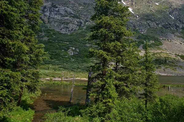 澄んだ山の頂上の湖につながるカラフルな岩の山の斜面 — ストック写真
