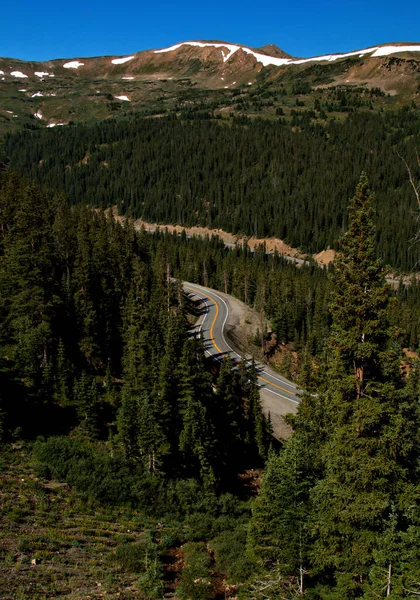 Bir dağ geçidinden aşağıya, bir otobana bakıyor. Manzaraya doğru ilerliyor.