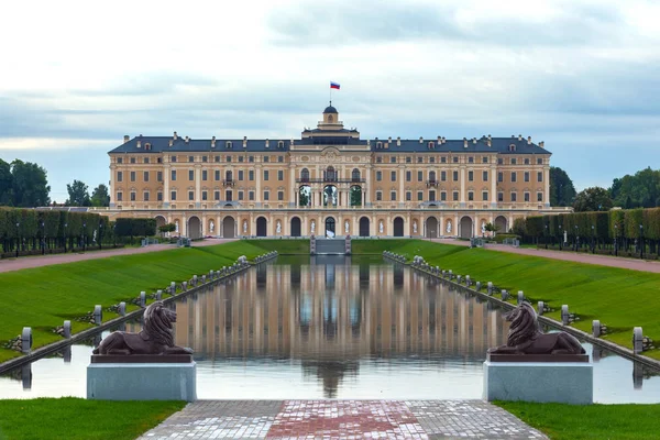 Rus Barok mimarisi, Aslan Taş heykellerin, göl ve park karşısında üç renkli bayrak ile görkemli kale. Konstantinovsky sarayda Strelna banliyösü Saint Petersburg, Rusya Federasyonu.