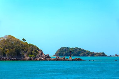Sürüler halinde Saladan Pier bay parlak kavurucu güneşin turkuaz yeşil mavi deniz ile giderken küçük bir ada deniz feneri. Adaman deniz, Koh Lanta, Krabi, Tayland.
