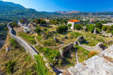 Harap duvarları, yeşil çim ile büyümüş arazi olan antik kentin iç avluya yolları, yukarıdan görünüm trodden. Yaz manzara kale kent Bar, Karadağ.