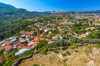 Eski bir taş duvarın özel küçük ile modern bir şehir binaları turuncu kırmızı taşlarla evleri harabeye havadan görünümü foothill. Yaz manzara kale kent Bar, Karadağ.