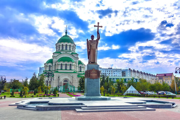 Площадь перед христианской церковью в центре города в пасмурный день с густыми голубыми облаками. Памятник Владимирскому и Владимирскому соборам, Астрахань, Россия
.