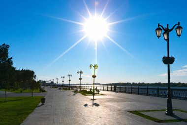 Volga Nehri parlak ışığında, parke döşeme ve pitoresk kenti üzerinden geniş kaldırım geçit bankaların yaya güvertede. Petrovskaya dolgu, Astrakhan, Rusya Federasyonu.