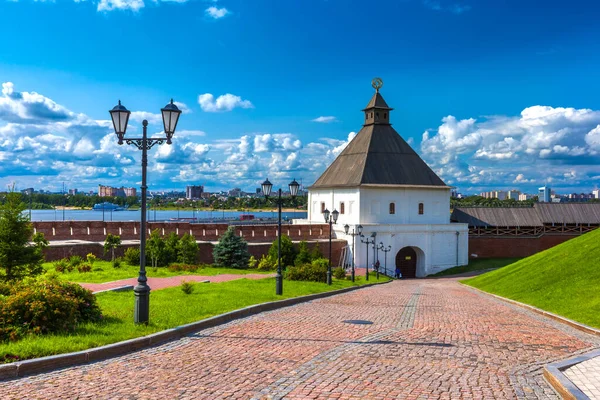 The Kazan Kremlin, Tatarstan, Russia. Cobblestone road to the Kremlin tower of white stone and a red brick wall overlooking the city and the river on a sunny day Royalty Free Stock Photos