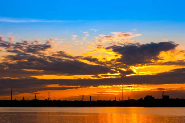 Kazanka River, Kazan, Tatarstan, Rússia. O pôr-do-sol laranja brilhante no céu azul com nuvens brancas é refletido na água. Noite romântica na costa da cidade russa — Fotografia de Stock