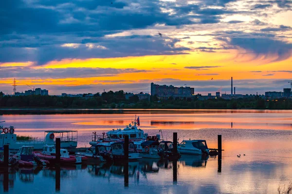 カザンカ川、カザン、タタールスタン、ロシア。丸みを帯びた鳥と青空に明るいオレンジ色の夕日の背景にボート救助ステーション。ロシアの街の海岸でロマンチックな夜 — ストック写真