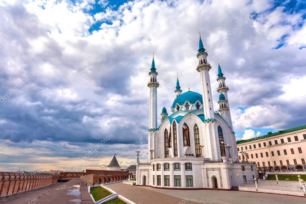 Kul Sharif Mosque in the Kazan Kremlin, Tatarstan, Russia - Jule 2015. A majestic white stone mosque with a blue roof surrounded by a red brick wall in cloudy weather with heavy rain clouds