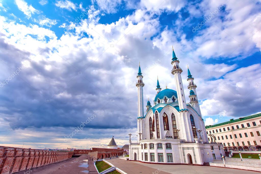 Kul Sharif Mosque in the Kazan Kremlin, Tatarstan, Russia - Jule 2015. A majestic white stone mosque with a blue roof surrounded by a red brick wall in cloudy weather with heavy rain clouds