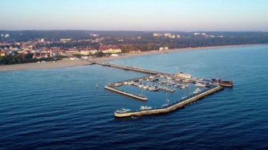 Sopot resort Polonya. Ahşap iskele (Molo) gezinti, Yat Limanı, yat, korsan turist gemisi, beach, eski fener, Spa, otel ve tatil altyapı ile. Hava 4 k uçuşu güneş doğarken video