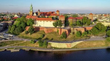 Krakow, Polonya. Wawel royal Castle ve Katedrali, Vistula Nehri, park, gezinti ve yürüyüş insanlar. Cracow içinde belgili tanımlık geçmiş tarihi kiliseler ile eski şehir. Hava 4 k uçuşu günbatımında video bahar