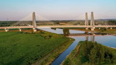 Yeni modern çift askılı köprü üzerinde Vistula Nehri, Krakow, Polonya ve gün batımında suda onun yansıması. Krakow etrafında çevre yolunun parçası. Hava uçuşu video
