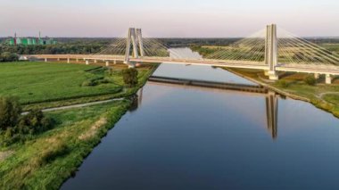 Yeni modern çift askılı köprü üzerinde Vistula Nehri, Krakow, Polonya ve gün batımında suda onun yansıması. Krakow etrafında çevre yolunun parçası. Hava yaklaşıyor ve video uçuyor
