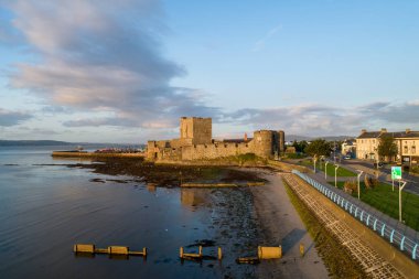 Carrickfergus gündoğumu ışık Belfast yakınındaki Ortaçağ Norman Kalesi. Marina, yatlar, groyne ve Belfast Lough havadan görünümü.