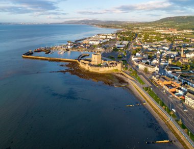 Belfast Lough. Carrickfergus gündoğumu ışık Ortaçağ Norman kalesi. Marina, yatlar, Otopark, dalgakıran, kasık, çökeller ve uzak Belfast görünümünde arka plan ile havadan görünümü