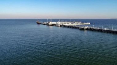 Ahşap iskele Limanı, korsan turist gemisi ve yatlar Polonya Gdansk yakınındaki Sopot beldesinde günbatımı ışığı ile marina. Hava 4k video