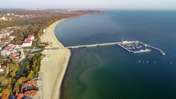 索波特度假村在波兰与木制码头 小帆船帆船和沙滩 空中4K接近视频在日出光 — 图库视频影像