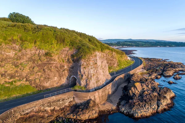 터널이 있는 해안 도로, 북아일랜드, 영국 스톡 사진