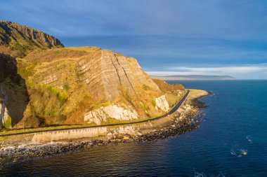 Kuzey İrlanda, İngiltere. Atlantik kıyısı. Cliffs ve Antrim Coast Road, namı diğer. Causeway Costal Route 'da. Avrupa 'nın en manzaralı kıyı yollarından biri. Güneş doğarken Garron Point yakınlarında hava manzarası