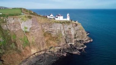 Carrickfergus ve Belfast yakınlarındaki Whitehead köyündeki Blackhead Deniz Feneri Atlantik kıyısında Antrim County, Kuzey İrlanda 'da kıyı yürüyüş yolu olan dik bir uçurumda. Hava görüntüleme videosu