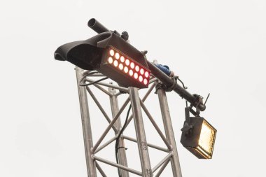 Gri bir gökyüzü, büyük arama ışıkları bir arka plan üzerinde ışık ekipmanları