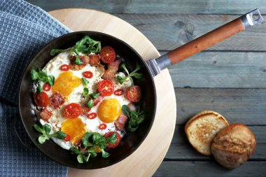 sahanda yumurta ile pastırma domates ve yeşillik, dökme demir tava, üstten görünüm