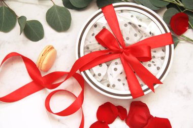 Güzel parlak kırmızı gül yaprakları beyaz arka plan üzerinde. Sevgililer günün kutlu olsun. Beyaz kutu kırmızı yay ile. Hediyelik