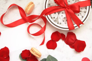 Güzel parlak kırmızı gül yaprakları beyaz arka plan üzerinde. Sevgililer günün kutlu olsun. Beyaz kutu kırmızı yay ile. Hediyelik