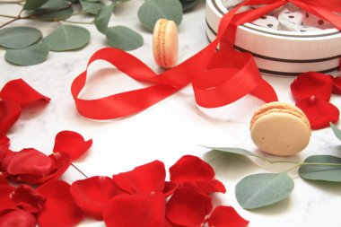 Gül yaprakları, macarons, yüzük ile kapak