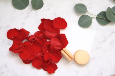 Gül yaprakları, kartpostal ve macaroons beyaz üzerine yapılan kalp