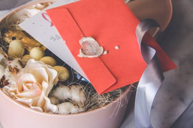 Üstten görünüm gül hediye kutusu gri şerit ve çikolata, şampanya, pamuk, Sevgililer günü kavramı ile'den oluşan. Pembe zarf, beyaz mühür mumu, kartpostal, Not