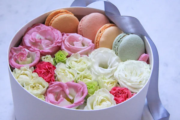 Круглый ящик с цветами и миндальным печеньем на мраморном фоне — стоковое фото