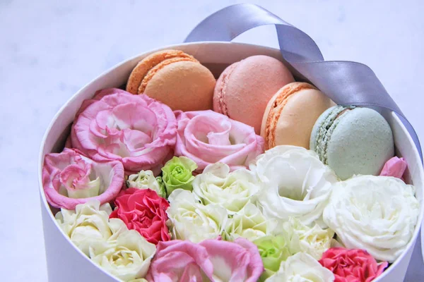 Круглый ящик с цветами и миндальным печеньем на мраморном фоне — стоковое фото