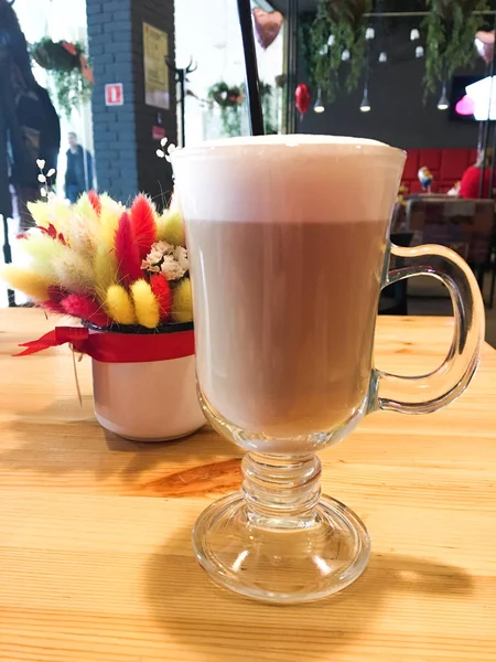 Uma caneca de cappuccino é fechada, decorada em cima da espuma na mesa do café. — Fotografia de Stock