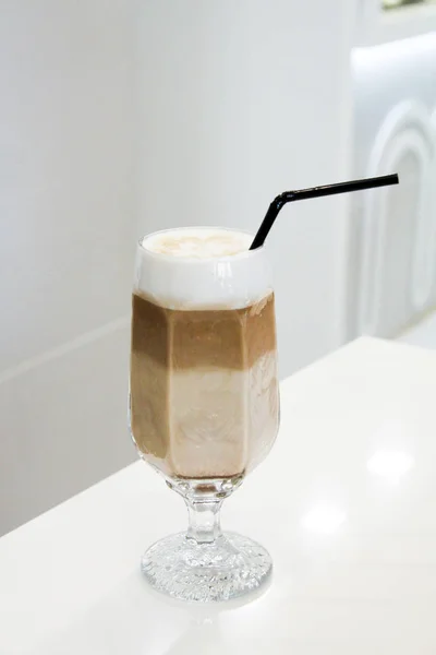Egy bögre cappuccino van zárva, díszített tetején a hab az asztalon a kávézóban — Stock Fotó
