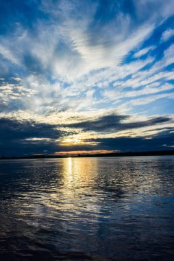 Sahilde yanan bulutlar ile gündoğumu deniz